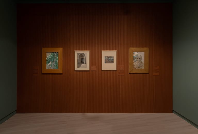 Dia Internacional dos Museus Sala de exposição com quatro obras emolduradas sobre parede de madeira em museu